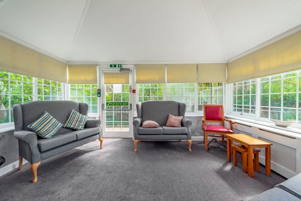 conservatory with dark grey carpet and sofas